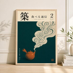 Könnte beinhalten: Gerahmter Kunstdruck mit einer japanisch anmutenden Illustration einer Teekanne und wirbelndem Dampf. Das Kunstwerk hat japanischen Text, eine orangefarbene Teekanne und einen dunkelblauen Hintergrund. Der Rahmen ist hell.
