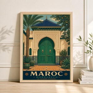 May include: A framed travel poster depicting a Moroccan scene. The image shows a green arched doorway, a blue tiled roof, and a palm tree. The poster has the word "MAROC" at the bottom, with "MARRAKECH" and "LE CHARME ÉTERNEL" below it.