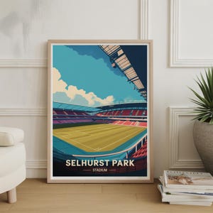 May include: A framed art print of Selhurst Park Stadium. The artwork depicts the stadium's exterior with a green field, red seating, and a blue sky with clouds. The text "SELHURST PARK STADIUM" is displayed at the bottom.