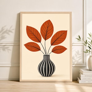 May include: A framed art print featuring a stylized illustration of a vase with orange leaves. The vase is black and white striped. The leaves are a warm orange color with black veins. The background is a light beige color. The frame is a light wood color.