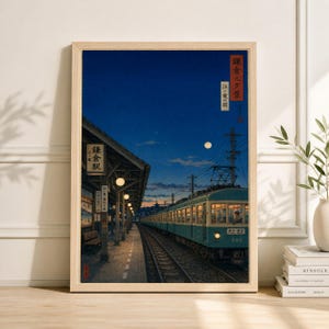 Può includere: Stampa incorniciata di una stazione ferroviaria giapponese al tramonto. Un treno turchese è sui binari, con la piattaforma e il tetto della stazione in primo piano. Il cielo è blu scuro con la luna piena. La stampa ha testo giapponese.