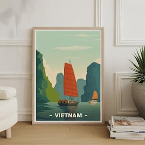 May include: Framed art print featuring a scenic view of Vietnam. The artwork depicts two traditional sailboats with orange sails on a calm sea, surrounded by green and blue mountains. The word "VIETNAM" is printed at the bottom.