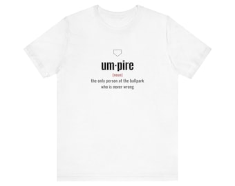 May include: A white short-sleeve t-shirt featuring a black graphic of a home plate icon above the text um-pire (noun) the only person at the ballpark who is never wrong. The text is printed in a clean sans-serif font on the center chest.