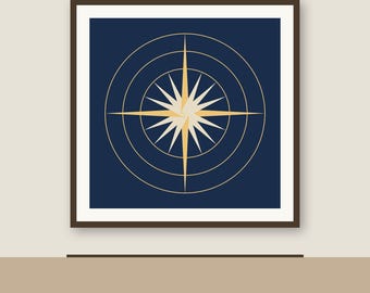 May include: A square framed wall art piece featuring a dark navy blue background with a centered gold compass rose design. The compass is composed of a multi-pointed star surrounded by three concentric thin gold circles within a white border.