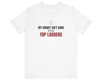 May include: A white short-sleeve t-shirt featuring a small graphic of a card holder above the text MY MONEY ISN'T GONE IT'S IN TOP LOADERS. The first two lines of text are in black, while the words TOP LOADERS are printed in red.