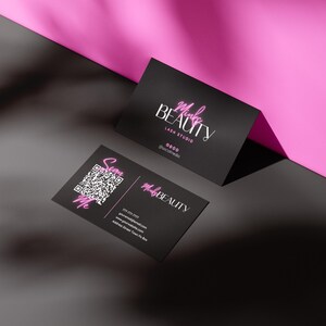 May include: Two black business cards with pink text. The top card reads "Make Beauty Lash Studio 0000 @makebeauty". The bottom card reads "Make Beauty" with contact information and a QR code that says "Scan Me".