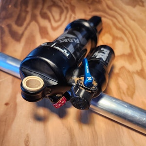 May include: A black and silver bicycle shock absorber with a blue lever and the word "FLOAT" printed on the side.