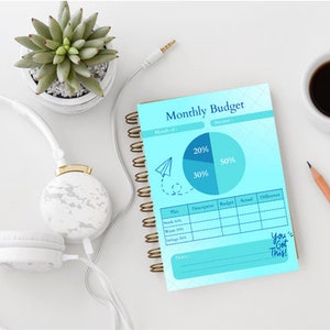 Może przedstawiać: Niebieski i biały miesięczny planer budżetu z wykresem kołowym pokazującym 20%, 30% i 50% budżetu. Planer zawiera sekcję dla "Plan", "Opis", "Budżet", "Rzeczywisty" i "Różnica". Tekst "You Got This!" jest napisany niebieskim atramentem na dole strony.