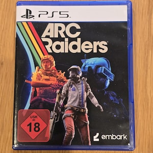 Könnte beinhalten: PS5-Spielhülle für "ARC Raiders" mit futuristischem Action-Thema. Das Cover zeigt zwei Figuren in Kampfausrüstung, mit dem Spieletitel in großen weißen Buchstaben. Eine USK 18-Einstufung ist sichtbar.