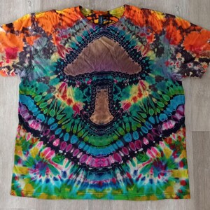 May include: A tie-dye t-shirt with a colorful psychedelic mushroom design in the center. The shirt is made of a soft, comfortable fabric and features a crew neck.