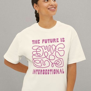 May include: A white t-shirt with a pink graphic that says "The future is intersectional" and features a pink abstract design.