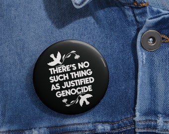 May include: A black button with white text that reads "There's no such thing as justified genocide". The button is pinned to a blue denim jacket.
