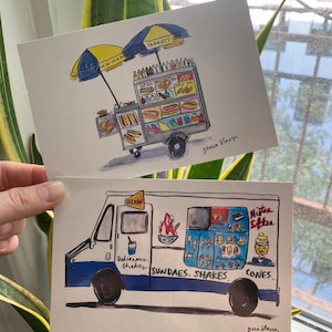 May include: Two watercolor illustrations of food carts. The first is a yellow and blue hot dog cart with a red and blue umbrella. The second is a blue and yellow ice cream truck with the words "Delicious Shakes, Sundaes, Shakes, Cones" written on the side. Both illustrations have the artist's signature.