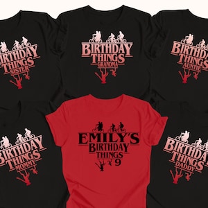 May include: Set of six black and red t-shirts with a Stranger Things theme. The shirts feature the text "Birthday Things" with a silhouette of characters from the show riding bikes. Each shirt has a different title: Sister, Grandma, Auntie, Mummy, Emily's 9, and Daddy.
