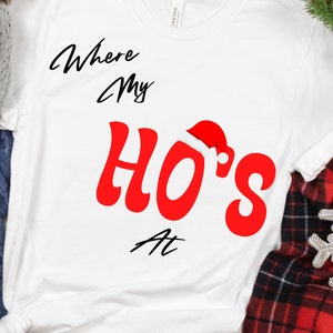 Könnte beinhalten: Weißes T-Shirt mit dem Text "Where My Ho's At" in Schwarz und Rot. Das Wort "Ho's" trägt einen roten Weihnachtsmann-Hut.