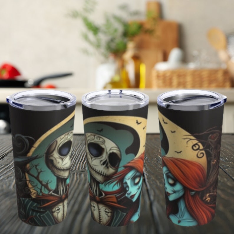 May include: Three stainless steel tumblers with a black background and a colorful image of Jack Skellington and Sally from the Nightmare Before Christmas movie. The tumblers have a clear lid.