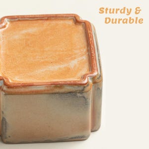 May include: A rectangular ceramic container with a light brown interior and a darker brown rim. The exterior has a mottled beige and gray appearance. The text "Sturdy & Durable" is visible in the upper right corner.
