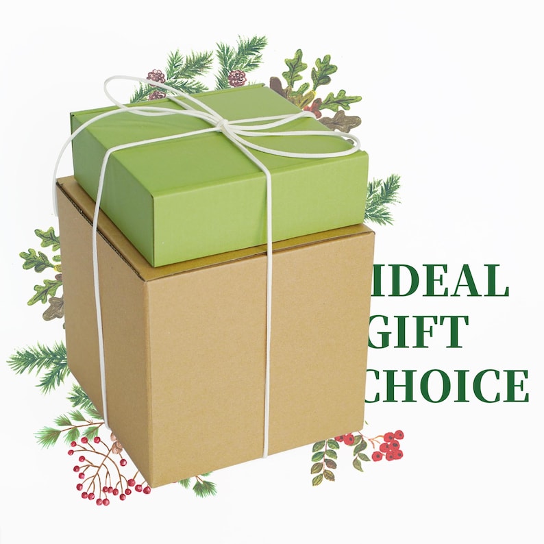 May include: Two stacked gift boxes, one green and one brown, tied with white string. The green box is on top of the brown box. The words "IDEAL GIFT CHOICE" are printed in green on the right side of the image. Decorative greenery surrounds the boxes.