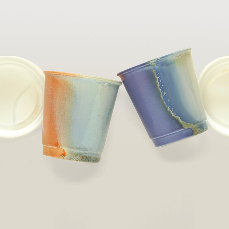 May include: Three ceramic cups with a unique, marbled glaze. The cups are in shades of blue, purple, and orange.