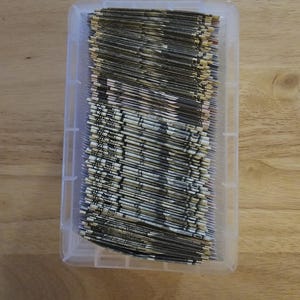 May include: A clear plastic storage container filled with a stack of folded dollar bills.