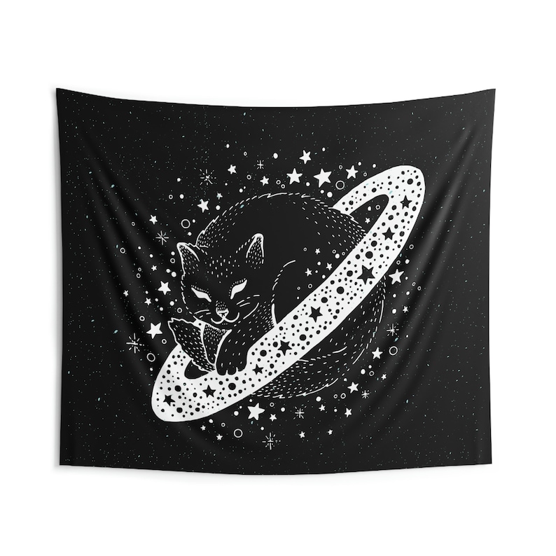 May include: Black and white tapestry featuring a sleeping cat inside a planet with a star-studded ring. The background is a dark starry sky. The cat is detailed with a whimsical design, creating a celestial theme.