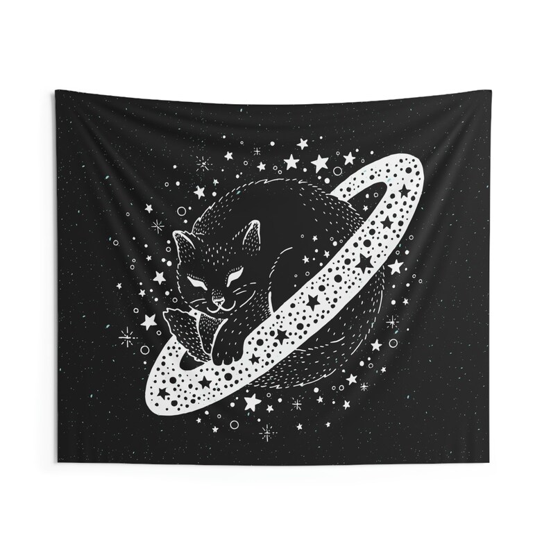 May include: Black tapestry featuring a white illustration of a cat sleeping on a planet with a dotted ring. The background is a starry night sky with white stars and dots. The cat is detailed with white outlines.