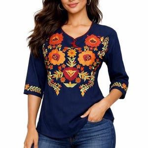 May include: A navy blue blouse with a V-neck and three-quarter sleeves. The blouse features vibrant floral embroidery in shades of orange, yellow, and red across the chest and on the sleeves. The embroidery adds a decorative touch to the top.