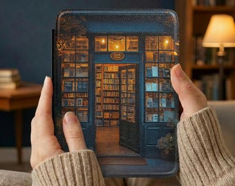 May include: An e-reader case featuring a detailed illustration of a bookstore facade. The image shows a blue door with a sign that reads "Book Store" and a warm, inviting interior filled with books. The case is held in a person's hands.