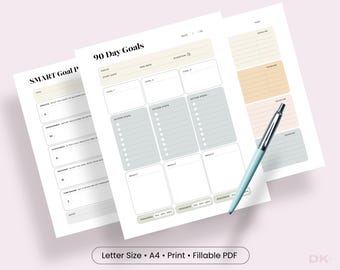 Puede incluir: Una plantilla de planificador de objetivos de 90 días y objetivos SMART impresa en papel blanco con detalles en beige, gris y melocotón. Las hojas incluyen secciones para enfoque, fechas, pasos de acción y seguimiento, con un bolígrafo azul claro.