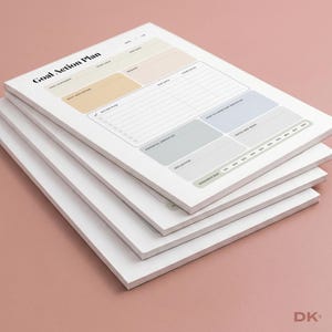 May include: A stack of white paper sheets featuring a Goal Action Plan template. The layout includes sections for goal statement, start and end dates, reward, action plan, due dates, obstacles, reflection, notes, and a progress bar from 10% to 100%.
