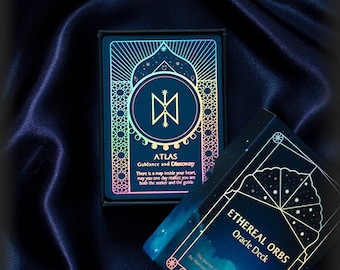 May include: Two oracle decks with holographic foil designs. The first deck is called "Atlas: Guidance and Discovery" and features a blue background with a white symbol. The second deck is called "Ethereal Orbs Oracle Deck" and features a blue and purple background with a star pattern.
