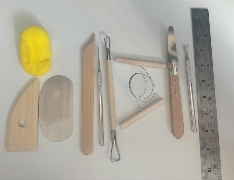 Pode incluir: Um conjunto de 10 ferramentas de cer&acirc;mica, incluindo uma r&eacute;gua de madeira, uma esponja amarela, uma esp&aacute;tula de madeira, uma esp&aacute;tula de metal, uma ferramenta de modelagem de madeira, uma ferramenta de modelagem de metal, uma ferramenta de la&ccedil;o de metal, uma ferramenta de fio de metal e duas ferramentas de conforma&ccedil;&atilde;o de madeira.