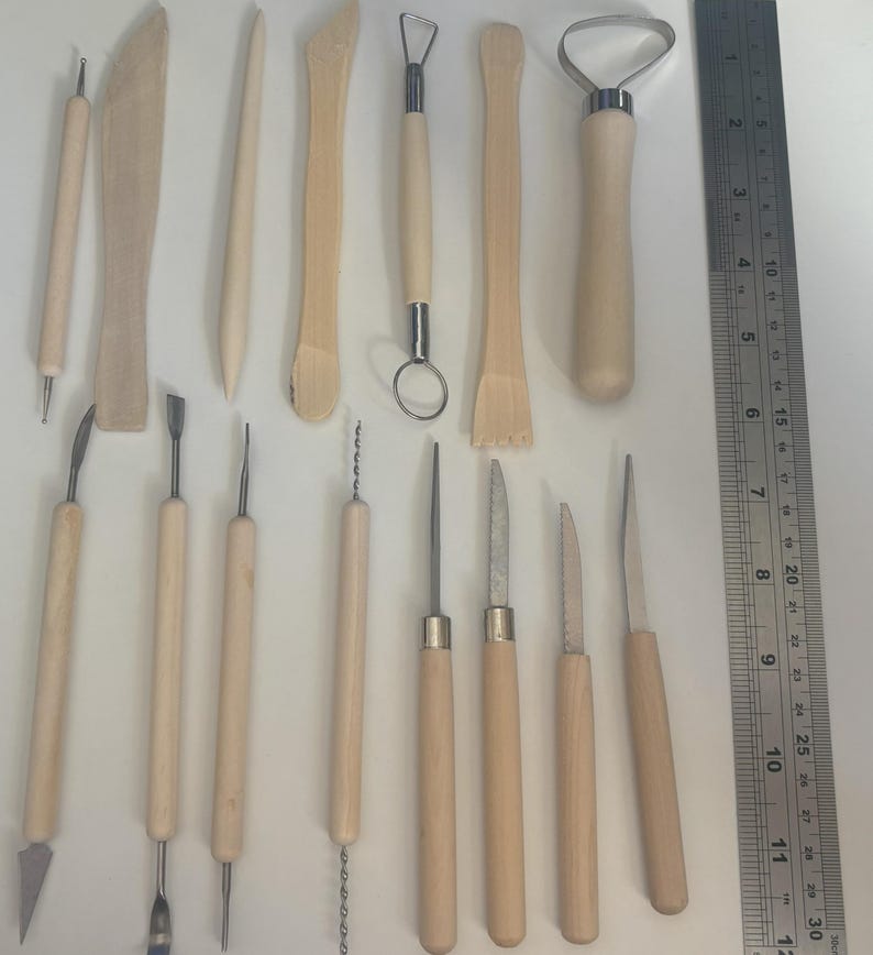 Pode incluir: Um conjunto de 14 ferramentas de escultura de madeira e metal para cer&acirc;mica, argila e artesanato. As ferramentas t&ecirc;m v&aacute;rias formas e tamanhos, incluindo uma ferramenta de la&ccedil;o, um raspador, uma ferramenta de costela e uma ferramenta de agulha.