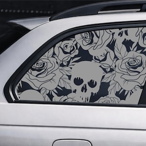 Könnte beinhalten: Ein hellgrauer Vinyl-Aufkleber auf einer Autoscheibe mit einem sich wiederholenden Muster aus detaillierten Rosen und einem zentralen Totenkopf mit Tropfeffekt. Das Design besteht aus hellgrauen Linien auf dem dunklen Glas des Fahrzeugs.