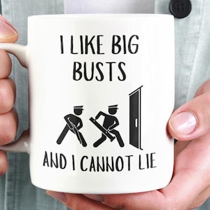May include: White ceramic mug with a black graphic that says "I like big busts and I cannot lie". The graphic also includes two stick figures pushing a door open.