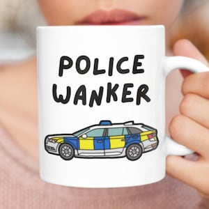 May include: White ceramic mug with a black and white illustration of a police car and the text "POLICE WANKER" printed on it.