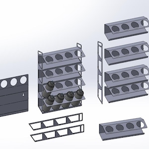 Puede incluir: Colección de especieros y organizadores de metal gris. La imagen muestra varias configuraciones, incluyendo estantes de pared con cuatro aberturas circulares, estantes de varios niveles y soportes individuales, todos diseñados para especias.