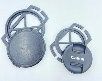 May include: Two black camera lens caps, one with a Canon logo, and two black plastic lens caps with a circular design.
