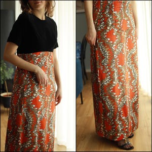 May include: A long, flowing dress with a black top and a colorful, abstract print skirt. The skirt features a swirling pattern of orange, brown, and white.