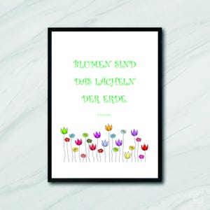 May include: A white framed print with a green quote that reads "Flowers are the smile of the earth." by R.W. Emerson. The quote is surrounded by a row of colorful flowers.