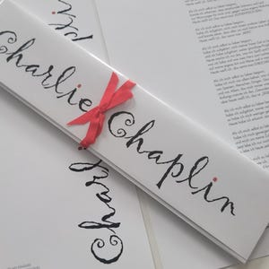 TARJETA con discurso de Charly Chaplin en su 70 cumpleaños envuelta como regalo con un lazo "Esto es vida" sabiduría