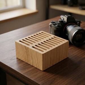 Peut inclure: Un bloc de bois carré de couleur brun clair présentant une série de fentes verticales parallèles découpées sur la surface supérieure. L'objet possède une texture de grain de bois naturel et une construction solide en forme de boîte.
