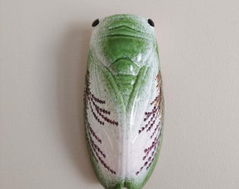 A handcrafted decorative ceramic cicada ornament