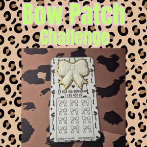May include: A white and gold bow-shaped patch is centered on a card with a bow-themed design. The card has the text "I LIKE BIG BOWS AND I CAN NOT LIE" and "Bow Patch Challenge" in the background. The background has a leopard print.
