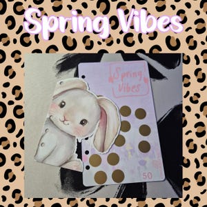 May include: A decorative card featuring a bunny illustration and the words "Spring Vibes". The card has gold dots and the number 50. The background has a leopard print pattern.