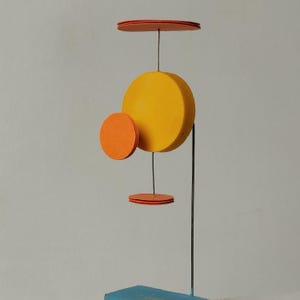 Oggetto surreale e minuscolo di colore arancione e giallo, scultura in resina e carta, altezza 11 cm (4,3")