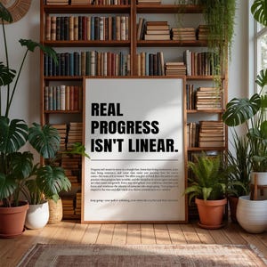 May include: A framed print with the text "REAL PROGRESS ISN'T LINEAR" in bold black letters. The print is in a room with bookshelves filled with books, potted plants, and a rug on the floor.