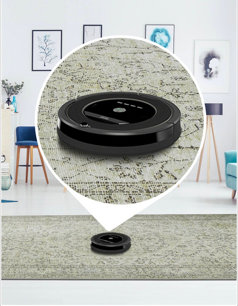 Pu&ograve; includere: Un aspirapolvere robot nero su un tappeto con motivo. L'aspirapolvere &egrave; rotondo e ha un design nero e argento.