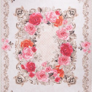May include: A beige rug with a floral design featuring pink, red, and orange roses. The roses are arranged in a circular pattern within a decorative frame.