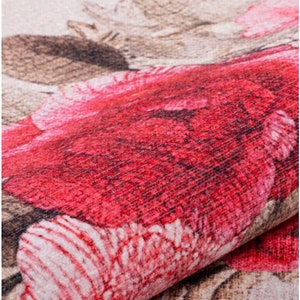 May include: Close-up of a red and pink floral patterned fabric. The fabric has a textured surface and a subtle sheen.